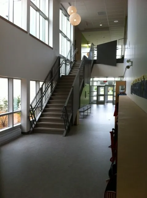 Escalier intérieur avec garde-corps en métal dans le hall vitré d'une école